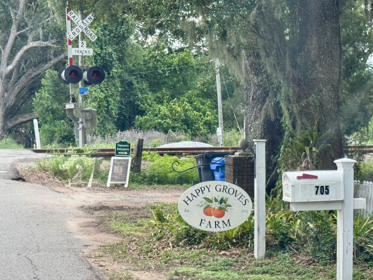 Happy Groves Farm sign and mailbox at 705 N Miller Rd in Valrico, next to the railroad crossing